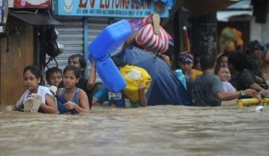 People wade through a flooded street und