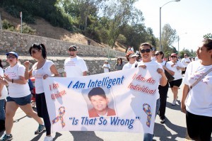 A team shows their autism support while walking with a large sign during Los Angeles Walk Now for Autism Speaks on Saturday, April 20, 2013 at the Rose Bowl in Pasadena. The 2013 LA Autism Walk hosted 40,000 attendees, raised over $1.8M for autism and is the largest autism walk in the country. Photo by Teresa Yu