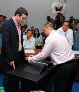 SMARTMATIC-TIM MACHINE DEMO: Senate President Juan Ponce Enrile and Senate Blue Ribbon Chairman Richard Gordon watch closely as Smartmatic-TIM sales director Cesar Flores (left) and technical support manager Miguel Avila (right) demonstrates the machine that will be used in the automation of 2010 polls during a Senate committee hearing today, July 6. “We can no longer stop automation if it can be done. The only thing that we are saying is yes, we will automate but we must not rely fully on automation because there is a possibility, although remote, that it may not work”, Enrile said. (Photo courtesy of www.senate.gov.ph)
