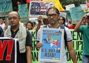 Protesters display placards and banners as they march towards the gates of the U.S. embassy during a protest in Manila July 4, 2013. About 300 activists marched on the streets on Thursday to denounce plans to grant U.S. troops access to a proposed new naval base which they say undermines Philippine sovereignty. (MNS photo)