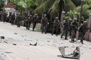 Security forces walks past debris scattered on a street after rebels from the Moro National Liberation Front (MNLF) clashed with government troops in Zamboanga city, southern Philippines September 9, 2013. Rebels took 30 civilian hostages in the southern Philippines on Monday and held security forces in a standoff as part of a drive to derail peace talks, officials said. Police commandos cordoned off parts of Zamboanga City on the island of Mindanao after a rogue faction of the Moro National Liberation Front (MNLF) took hostages and tried to march to the city hall to raise their flag, an army commander said.(MNS photo)