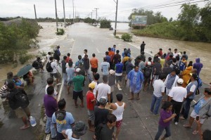Stranded commuters wait to get across floodwaters brought by Typhoon Santi along a main road of San Ildefonso, Bulacan province, north of Manila October 12, 2013. At least five people were reported killed in the wake of bad weather conditions from Typhoon Santi (Nari), the National Disaster Risk Reduction and Management Council said Saturday. (MNS photo)