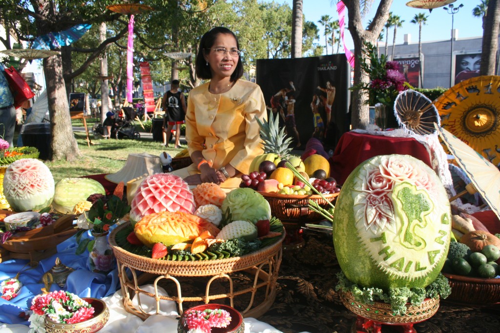 A map of Thailand is engraved in the watermelon as a Thai lady proudly displays sculptures of food art at the festival.