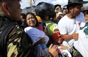 A woman and her child plead from the frantic crowd to be prioritized on an evacuation flight in Tacloban, central Philippines, Thursday, Nov. 14, 2013. Typhoon Haiyan, one of the most powerful storms on record, hit the country's eastern seaboard on Friday, destroying tens of thousands of buildings and displacing hundreds of thousands of people. (MNS photo)