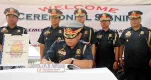 Philippine National Police Director General Alan Purisima signs the Implementing Rules and Regulation (IRR) of Republic Act No. 10591 or the Comprehensive Law on Firearms and Ammunition during the flag-raising ceremony on Monday (Nov. 25, 2013) at the PNP Headquarters in Camp Crame, Quezon City. Purisima said the IRR of the new gun law will enable the PNP to curb down gun-related crimes and establish effective firearms control in the land. (MNS photo)