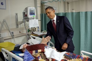 "For the President, this was one of the most poignant moments of the his first term. He was visiting wounded warriors in the intensive care unit at Bagram Air Field in Afghanistan. He had just presented a Purple Heart to Sgt. Chase Haag, who had been injured by an IED just hours before. Sgt. Haag was covered with a blanket and it was difficult to see how badly he was injured. He was also seemingly unconscious, or perhaps just asleep. The President whispered in his ear so not to wake him. Just then, there was a rustling under the blanket and Sgt. Haag, eyes still closed, reached his hand out to shake hands with the President. 'I'll never forget that moment,' someone else in the room later told me." (Official White House Photo by Pete Souza)