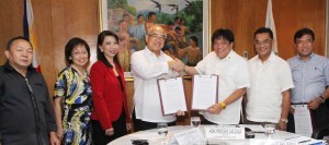 SSS President and Chief Executive Officer (PCEO) Emilio de Quiros, Jr. (center) and Agriculture Secretary Proceso Alcala (3rd from right) shaking hands during the signing, with both SSS Senior Vice President for Account Management Judy Frances See (3rd from left) and DA-ATI Director Asterio Saliot (2nd from right) serving as witnesses. Also present were (from left) SSS Officer-in-Charge for Cooperatives and Informal Sector Department Honorato Carranza Jr., SSS Special Assistant to the PCEO Ma. Lourdes Mendoza, and DA-ATI Extension Program and Partnership Division Chief Engr. Renato dela Cruz.