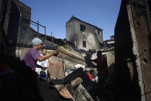 A Filipino collects salvageable materials among debris following an overnight fire that razed a slum area in Manila, Philippines, 05 April 2014. According to the Bureau of the chief fire inspector, around 100 houses were destroyed at a shantytown leaving more than 200 families homeless. (MNS photo)